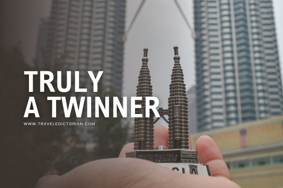 A hand with a small replica of Petronas Twin Towers